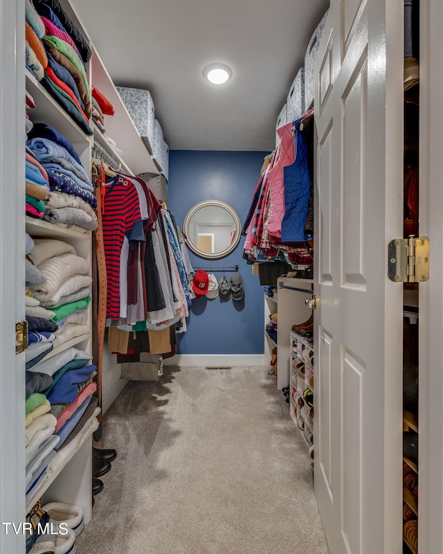 walk in closet featuring light colored carpet