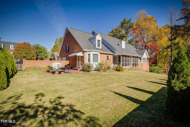 back of house with a lawn, a patio area, and a sunroom