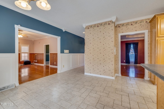 unfurnished room with ceiling fan, crown molding, and light tile patterned floors