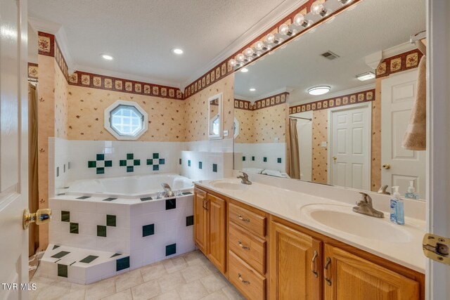 bathroom with ornamental molding, tile patterned flooring, double vanity, tile walls, and a bathtub