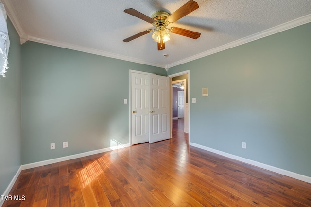 empty room featuring ceiling fan, ornamental molding, and wood-type flooring