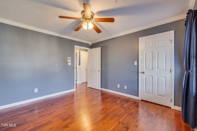 empty room with ceiling fan, a textured ceiling, crown molding, and hardwood / wood-style floors