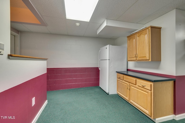 kitchen with a drop ceiling, carpet flooring, and white fridge