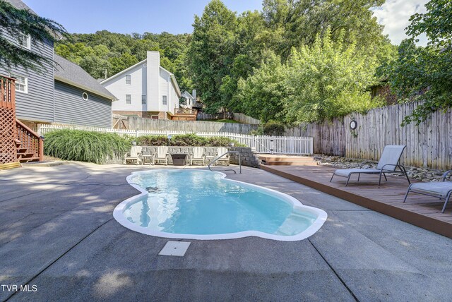 view of pool featuring a wooden deck and a patio area