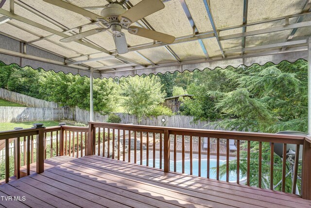 wooden terrace with ceiling fan and a swimming pool