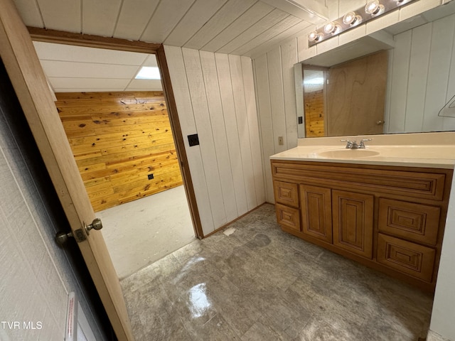 bathroom featuring vanity and wood walls