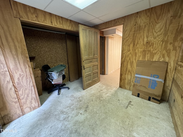 home office featuring a drop ceiling and wooden walls