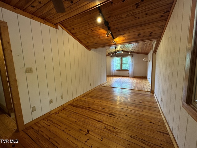 bonus room with ceiling fan, lofted ceiling with beams, wood walls, wood ceiling, and light wood-type flooring