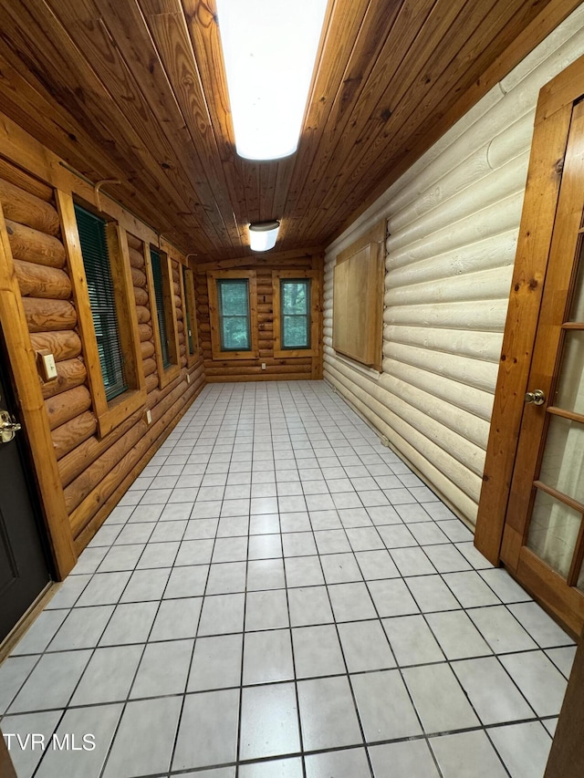 interior space with log walls, light tile patterned floors, and wooden ceiling