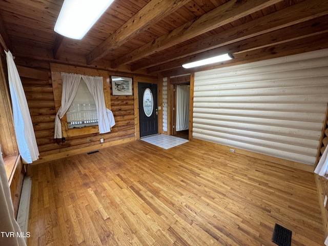 foyer entrance with beamed ceiling, wood-type flooring, rustic walls, and wooden ceiling