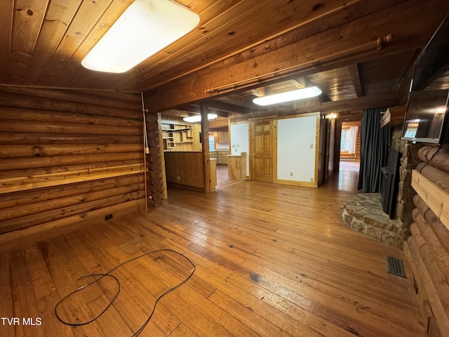 unfurnished living room featuring hardwood / wood-style floors, wood ceiling, and rustic walls