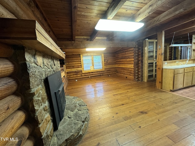 interior space with heating unit, log walls, light hardwood / wood-style flooring, wooden ceiling, and vaulted ceiling with beams