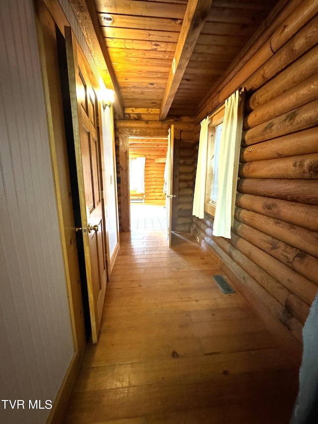 hallway featuring wood ceiling, log walls, beamed ceiling, and light hardwood / wood-style floors