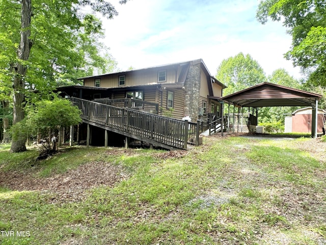 rear view of property with a deck and a storage unit