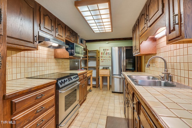117 Lakeside Dr, Gray, TN 37615 - kitchen featuring light tile patterned flooring, appliances with stainless steel finishes, tile countertops, sink, and backsplash