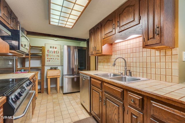 117 Lakeside Dr, Gray, TN 37615 - kitchen with sink, tile countertops, light tile patterned floors, appliances with stainless steel finishes, and decorative backsplash