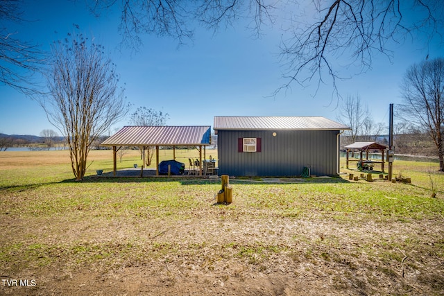 view of home's exterior featuring a lawn, an outdoor structure, and a gazebo