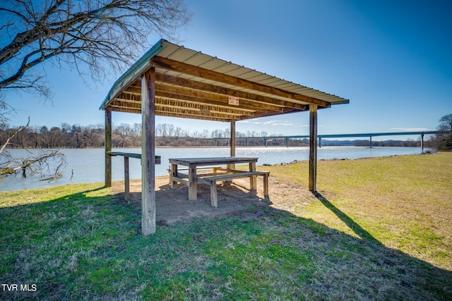 exterior space with a water view and a lawn