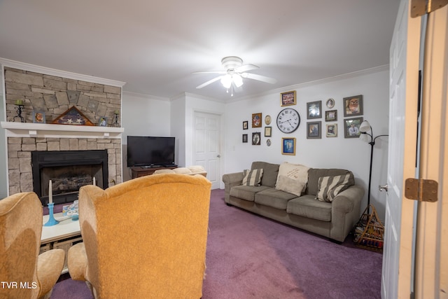 carpeted living room featuring crown molding, ceiling fan, and a stone fireplace