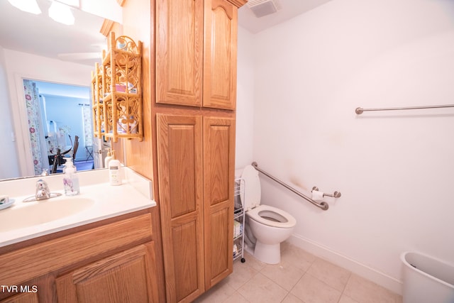 bathroom with toilet, tile flooring, and vanity