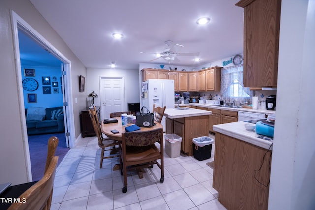 kitchen featuring light tile floors, a center island, ceiling fan, and sink