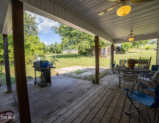 wooden terrace with a lawn, ceiling fan, and a patio