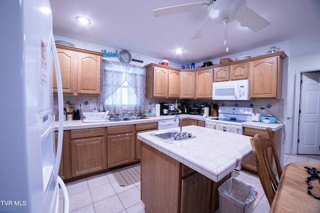 kitchen with ceiling fan, white appliances, an island with sink, and tasteful backsplash