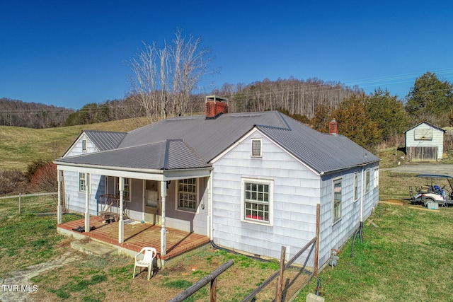 view of front facade with a front lawn, an outdoor structure, and a porch