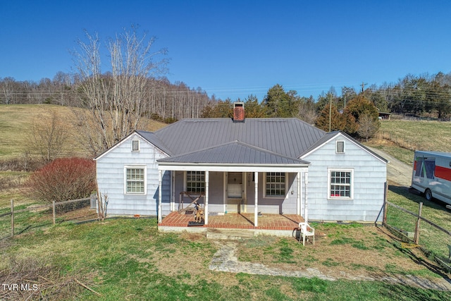 back of property with a yard and a porch