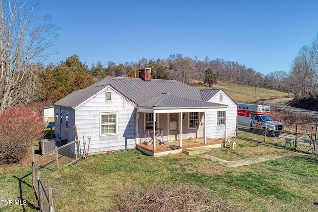 back of house featuring covered porch and a yard