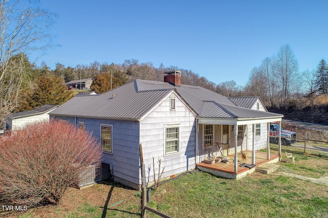 view of outdoor structure with covered porch and a lawn