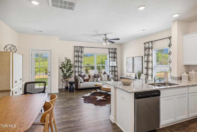 kitchen with sink, white cabinetry, light stone counters, stainless steel dishwasher, and dark hardwood / wood-style floors