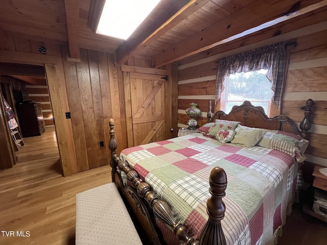 bedroom with beam ceiling, hardwood / wood-style flooring, wooden ceiling, and wood walls