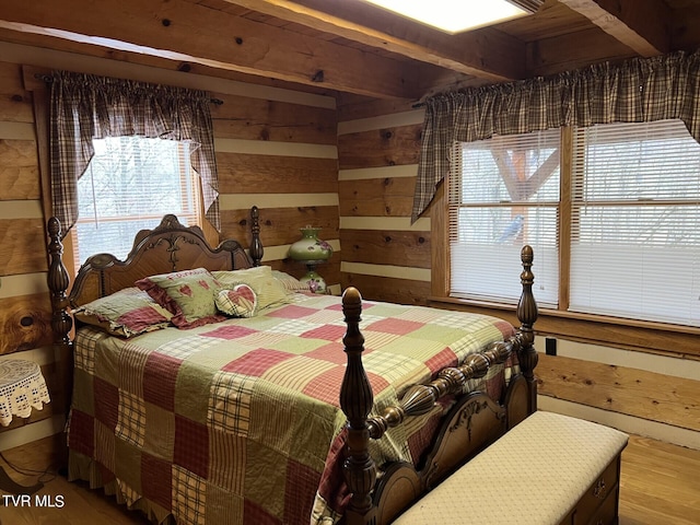 bedroom with hardwood / wood-style flooring and wooden walls