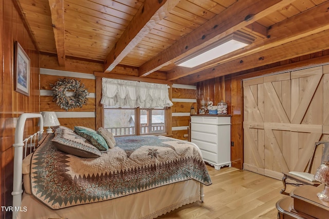 bedroom featuring beamed ceiling, light wood-type flooring, wooden ceiling, and wooden walls