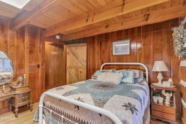 bedroom with beamed ceiling, wooden ceiling, hardwood / wood-style floors, and wooden walls