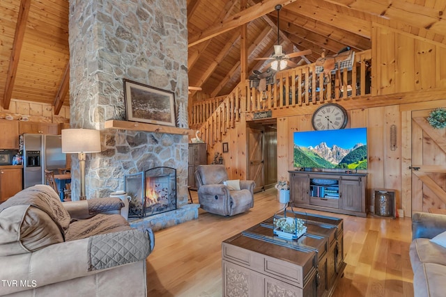 living room featuring beamed ceiling, wood walls, light hardwood / wood-style floors, and high vaulted ceiling