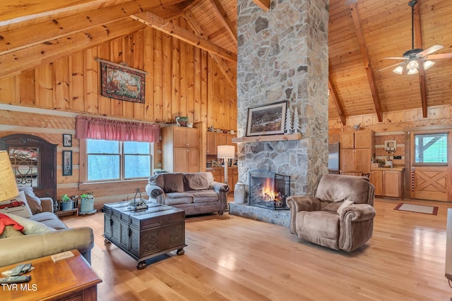 living room with beamed ceiling, wooden walls, and high vaulted ceiling