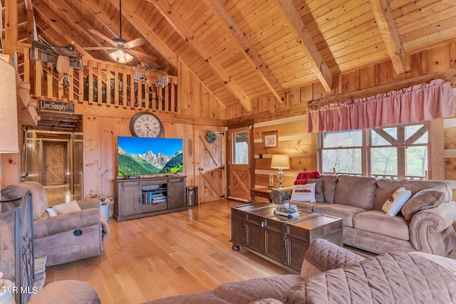 living room with beamed ceiling, wood walls, light wood-type flooring, and wood ceiling