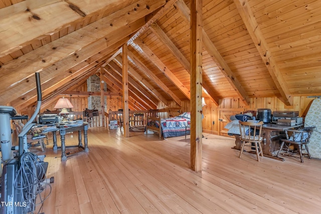 bedroom with lofted ceiling with beams, wooden walls, wooden ceiling, and light hardwood / wood-style floors