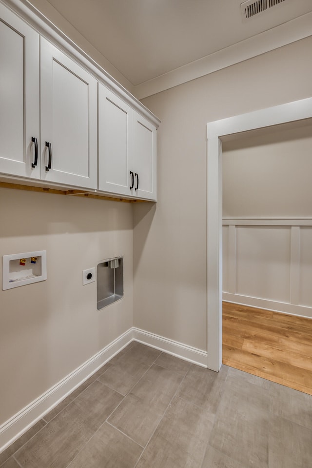 clothes washing area with cabinets, hookup for an electric dryer, light wood-type flooring, washer hookup, and crown molding