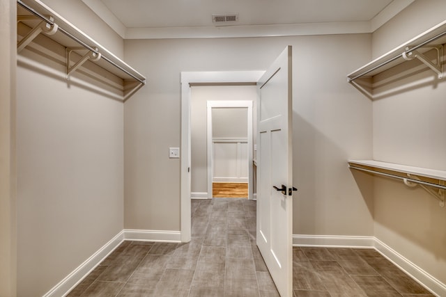 walk in closet with light wood-type flooring