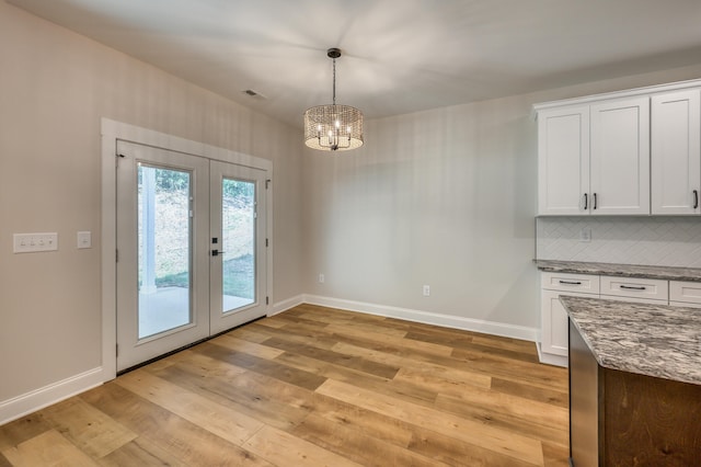 doorway to outside with an inviting chandelier, light hardwood / wood-style flooring, and french doors