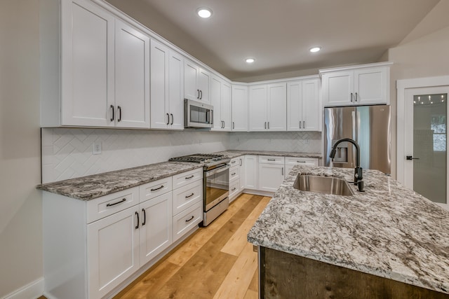 kitchen featuring white cabinetry, appliances with stainless steel finishes, and light hardwood / wood-style floors