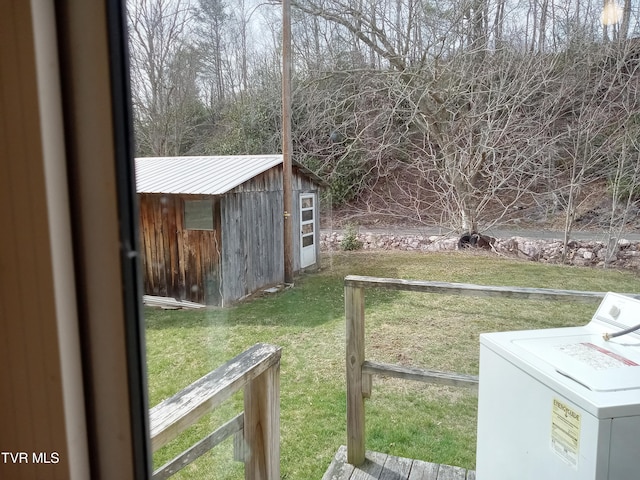 view of yard featuring an outdoor structure and washer / clothes dryer