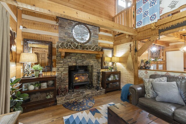 570 Stephen Brooks Rd, Greeneville, TN 37743 - living room featuring a towering ceiling, wood walls, a wood stove, and hardwood / wood-style flooring