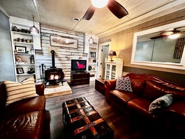 570 Stephen Brooks Rd, Greeneville, TN 37743 - living area featuring a ceiling fan, a wood stove, wood finished floors, and wooden walls