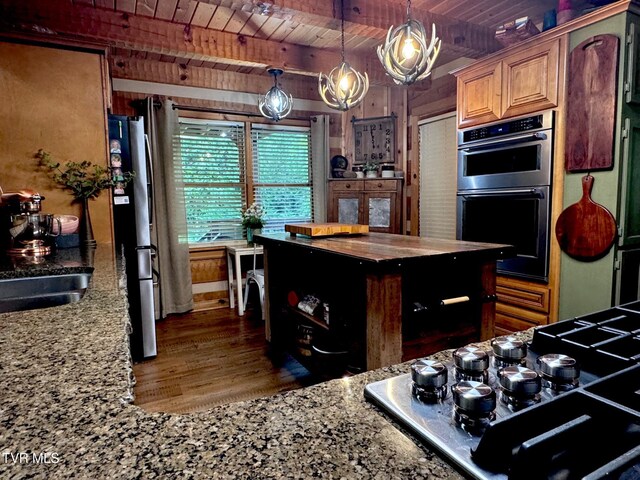 570 Stephen Brooks Rd, Greeneville, TN 37743 - kitchen featuring wooden ceiling with exposed beams, stainless steel appliances, wood finished floors, light stone counters, and pendant lighting