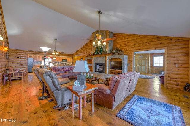 living room with a stone fireplace, light hardwood / wood-style flooring, log walls, and ceiling fan