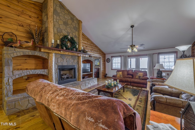 living room with a fireplace, lofted ceiling, light wood-type flooring, and plenty of natural light